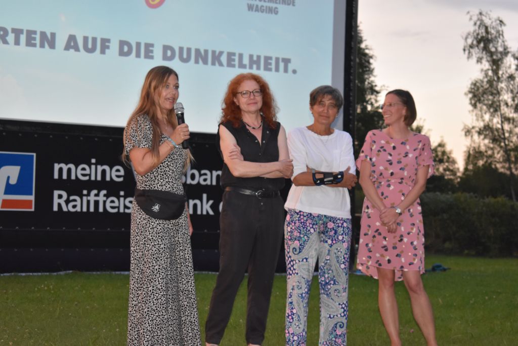 Vor der Kulisse der Waginger Filmtage stehen vier Frauen nebeneinander. Die rechte redet ins Mikro.